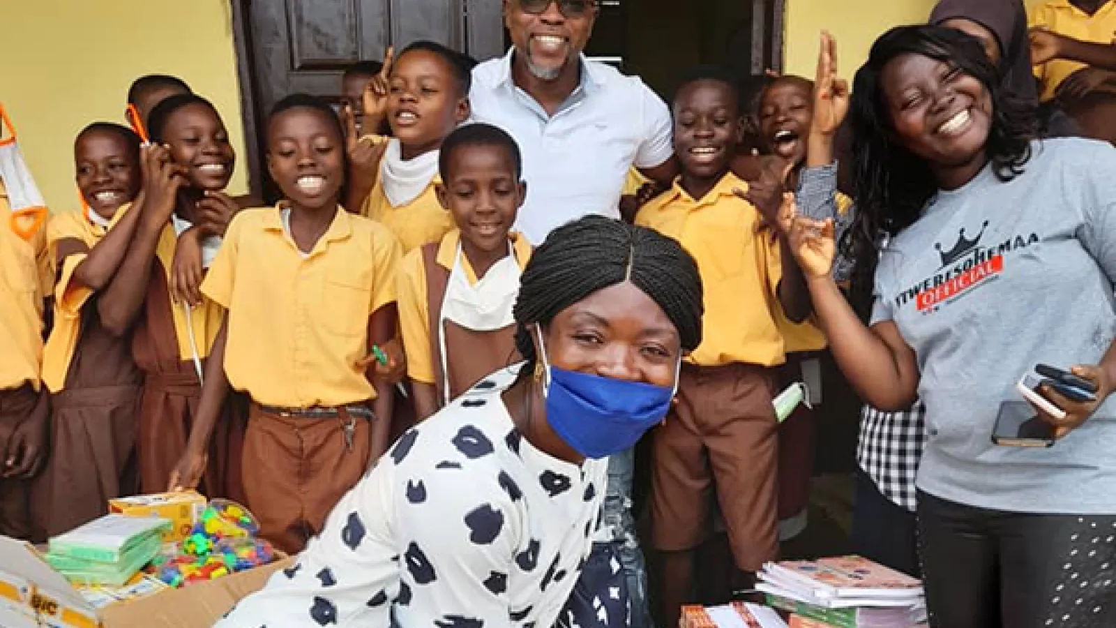 Students and staff at a school in Ghana receiving textbooks