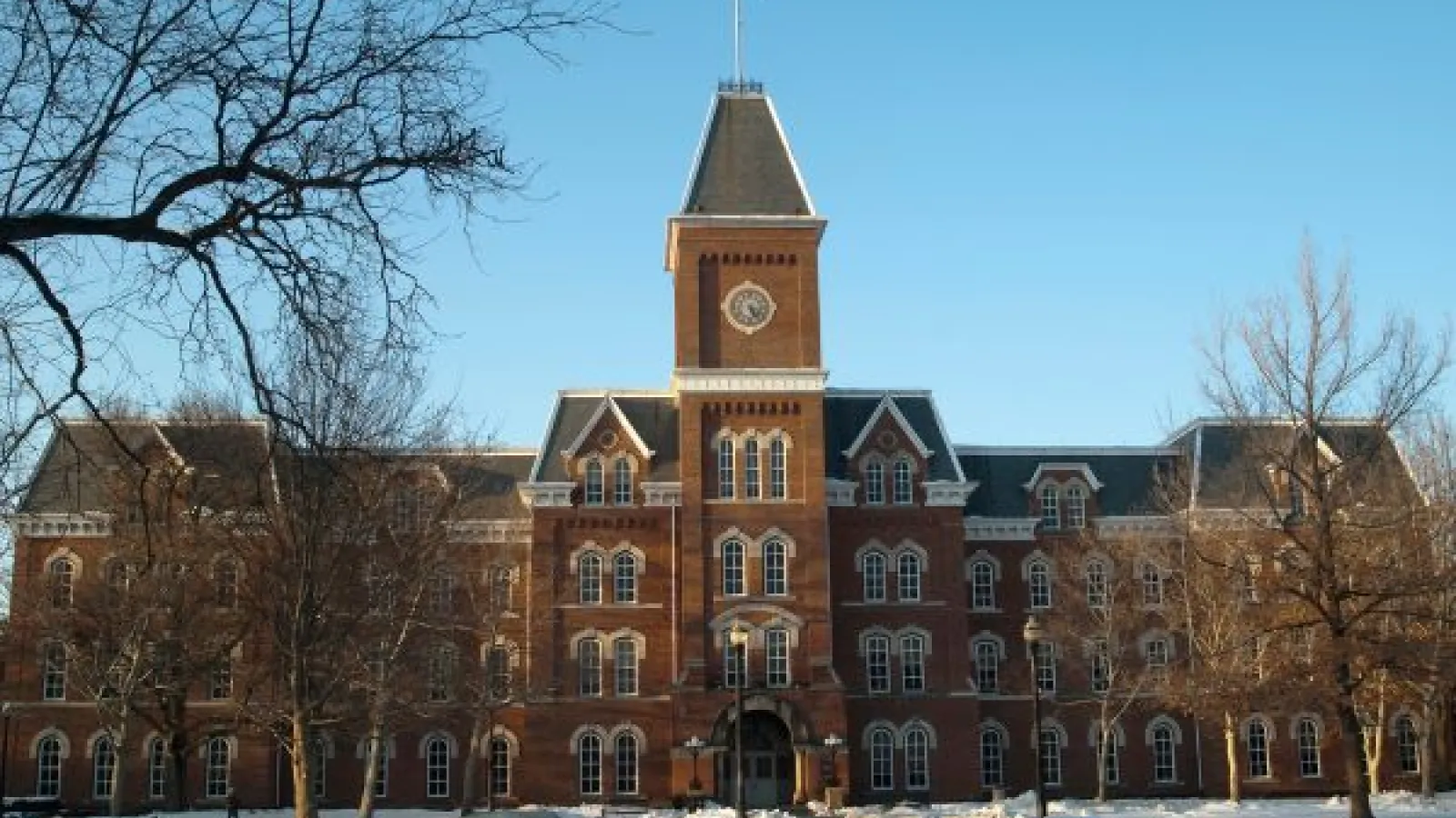University Hall, a brick building with a tall clocktower, on a clear winter day