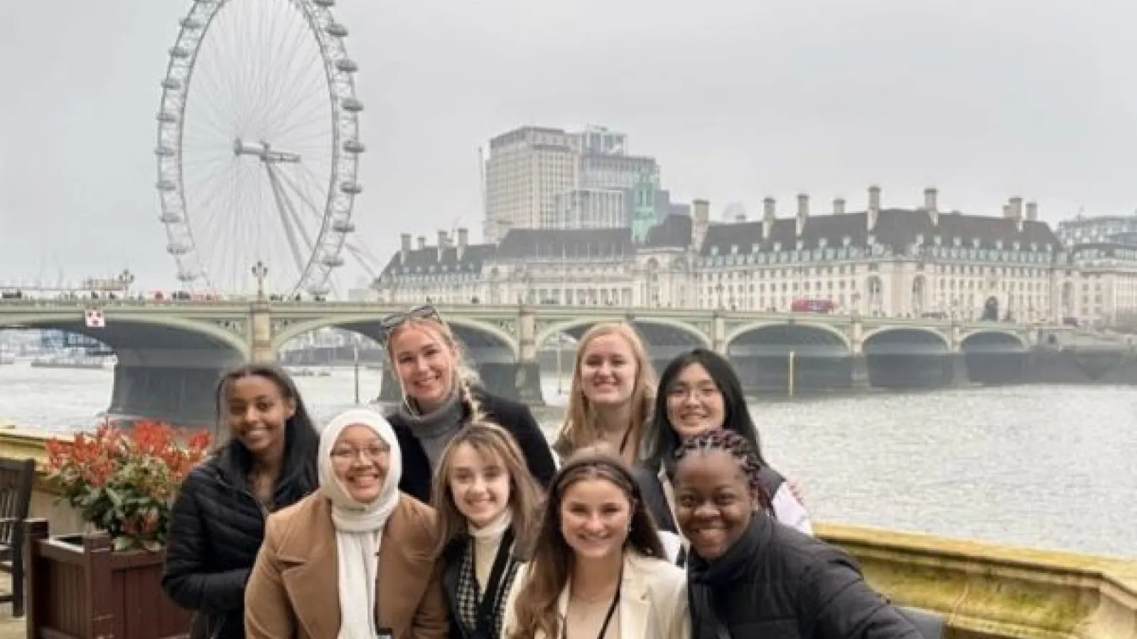 students pose in front of the London Eye