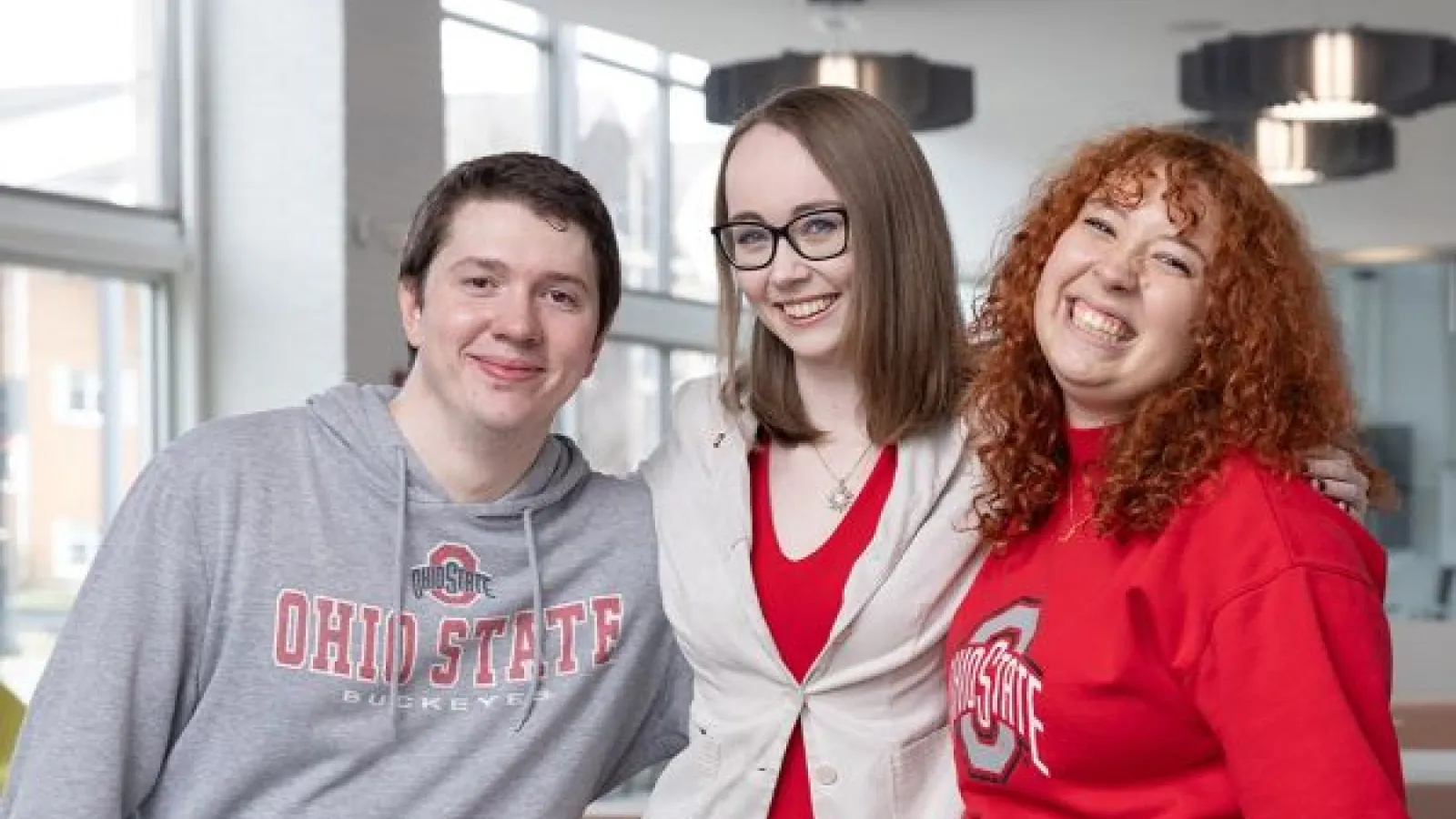 three people smile at the camera