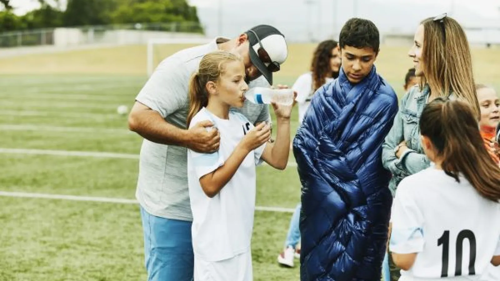 parents and their kids at a soccer field