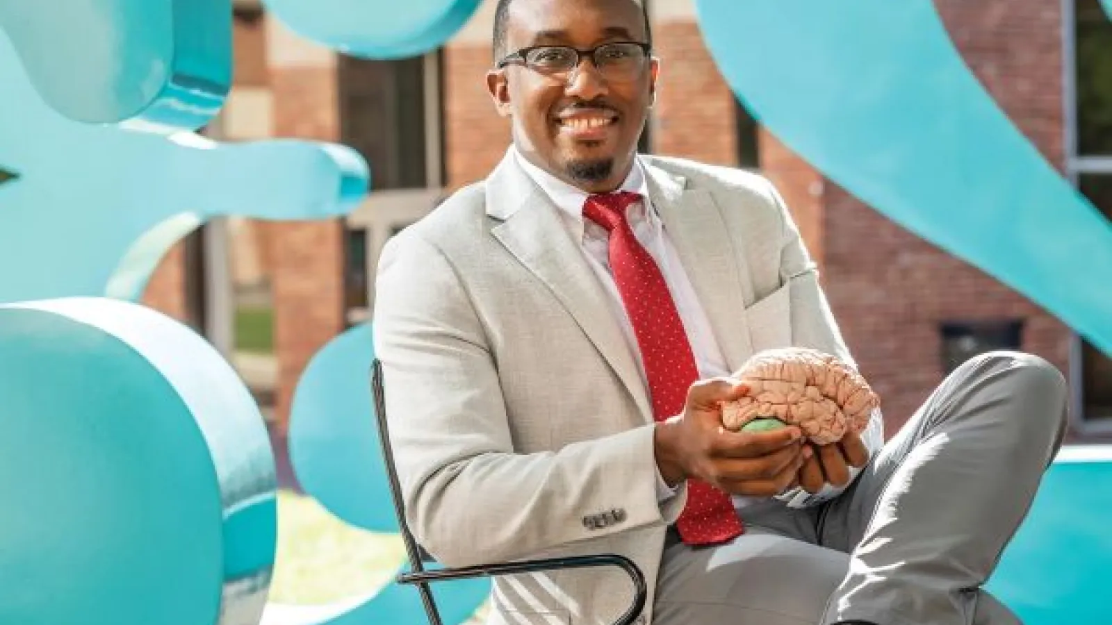 Jeremy Grant, holding a replica of a brain