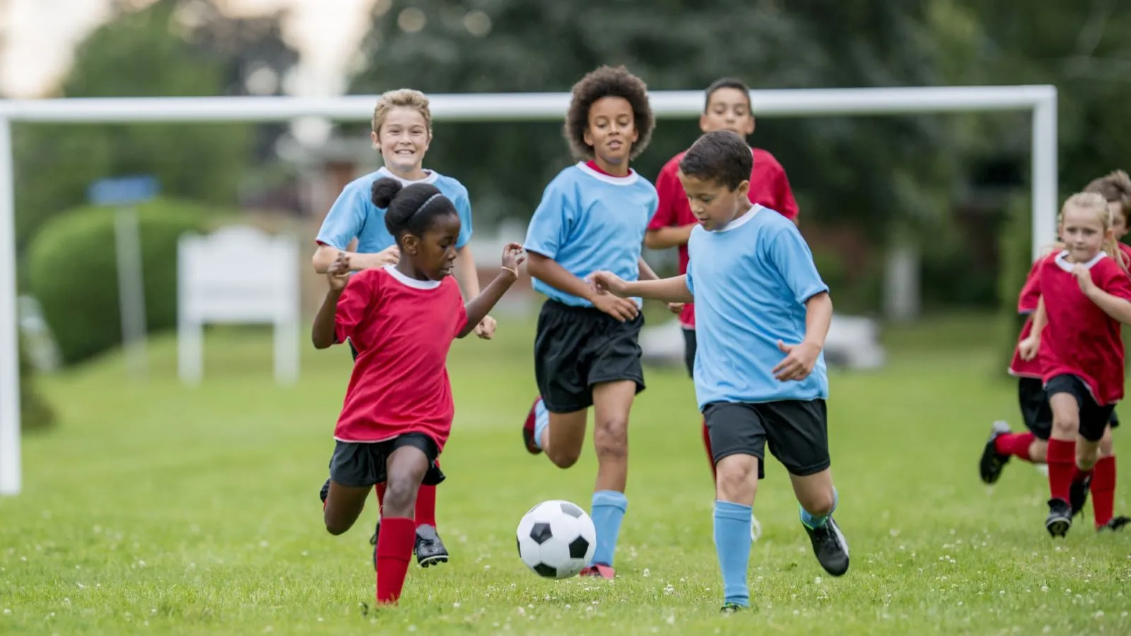 kids playing soccer on a grass pitch