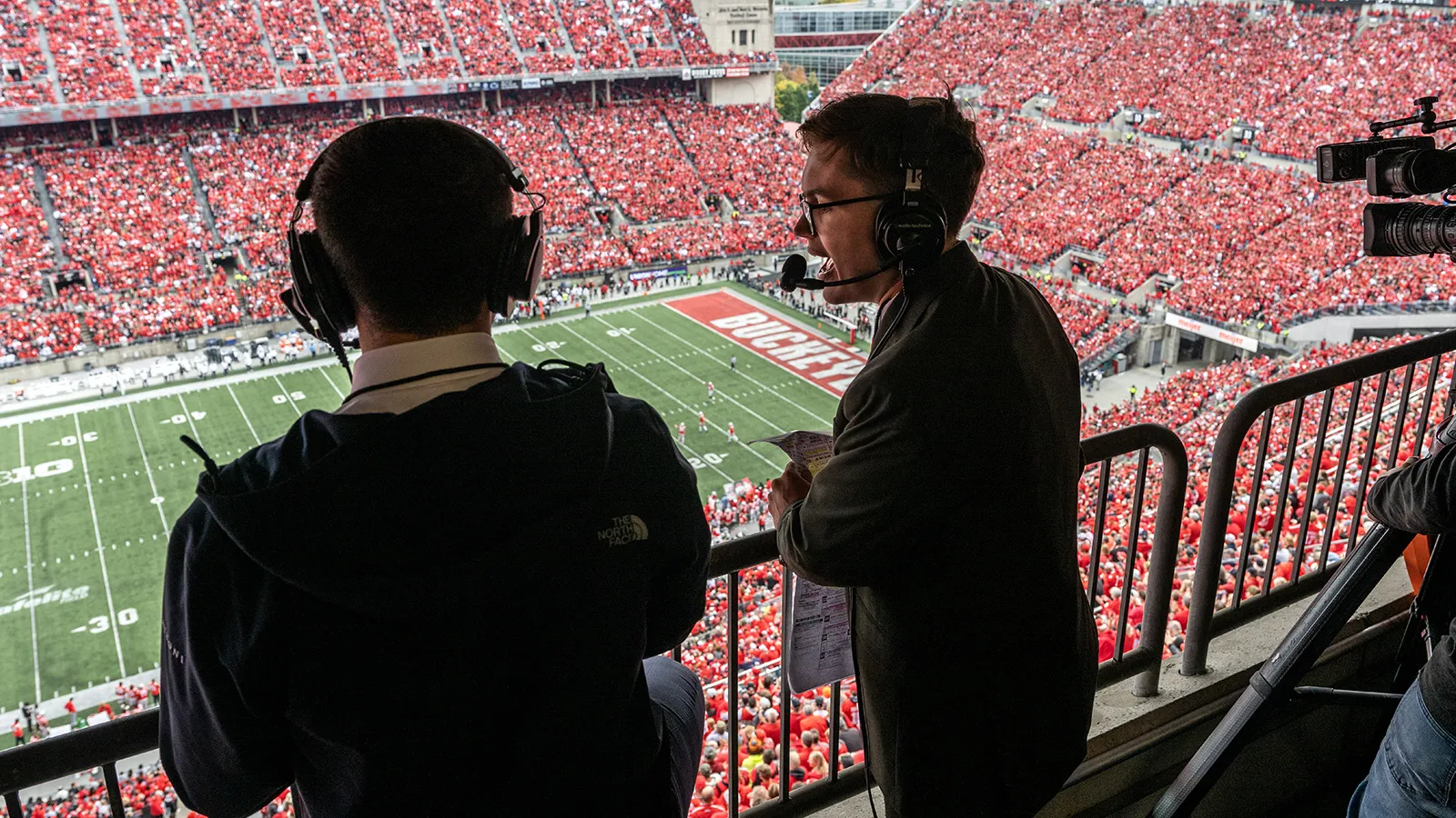 Two student journalists broadcasting from The Shoe
