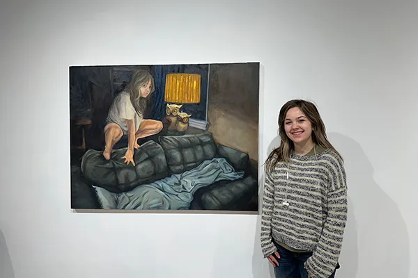 Ohio State student artist Kasmira Snyder next to one of her paintings