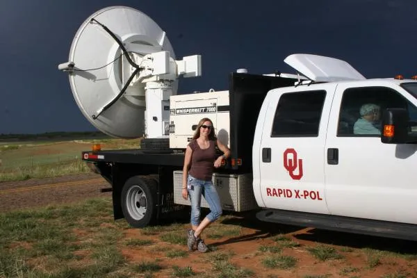 Jana Houser standing next to a mobile weather radar