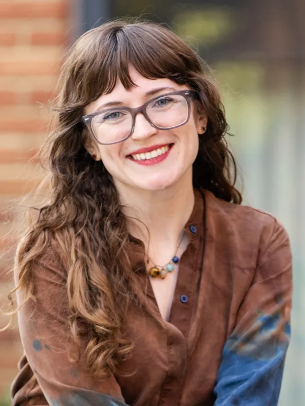 Woman with brown hair and glasses smiling