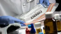 Forensic scientist working in the lab with evidence bag